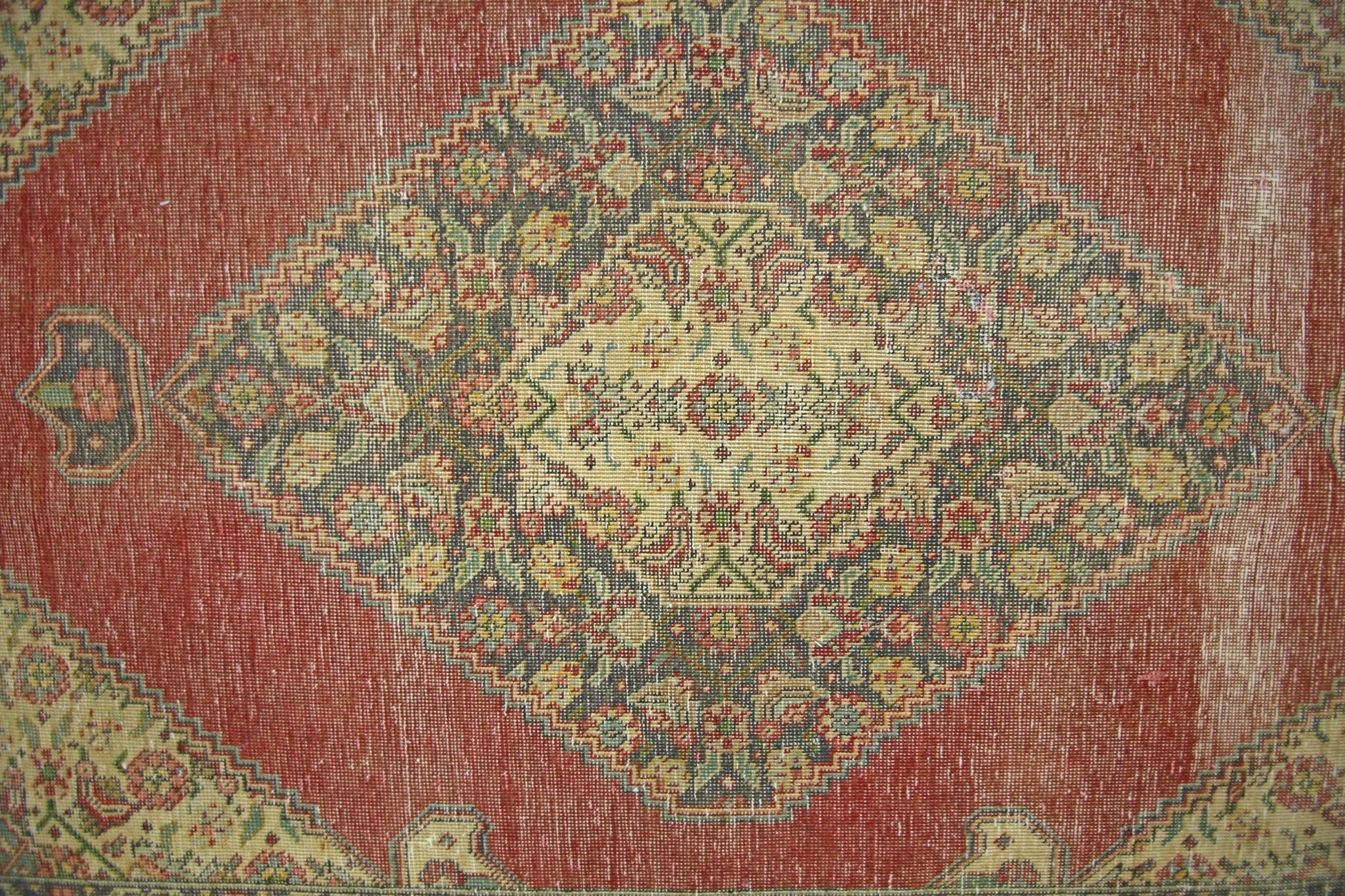 A vintage Persian rug featuring a central diamond medallion with intricate floral patterns.