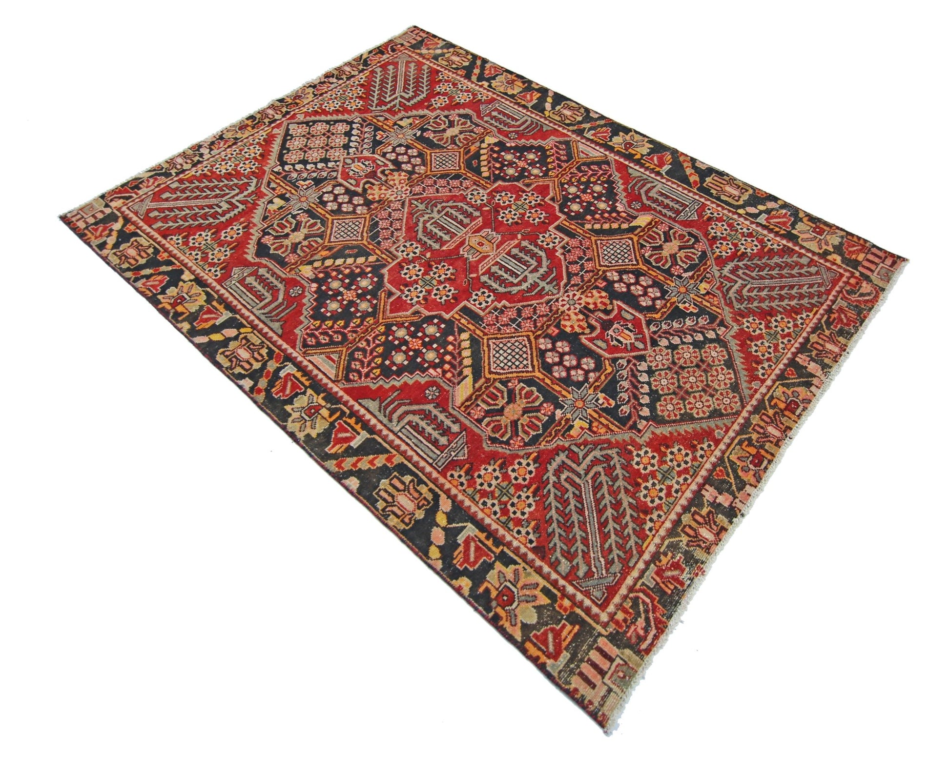 A vintage Persian Tabriz rug featuring intricate geometric patterns in red, black, and cream tones.