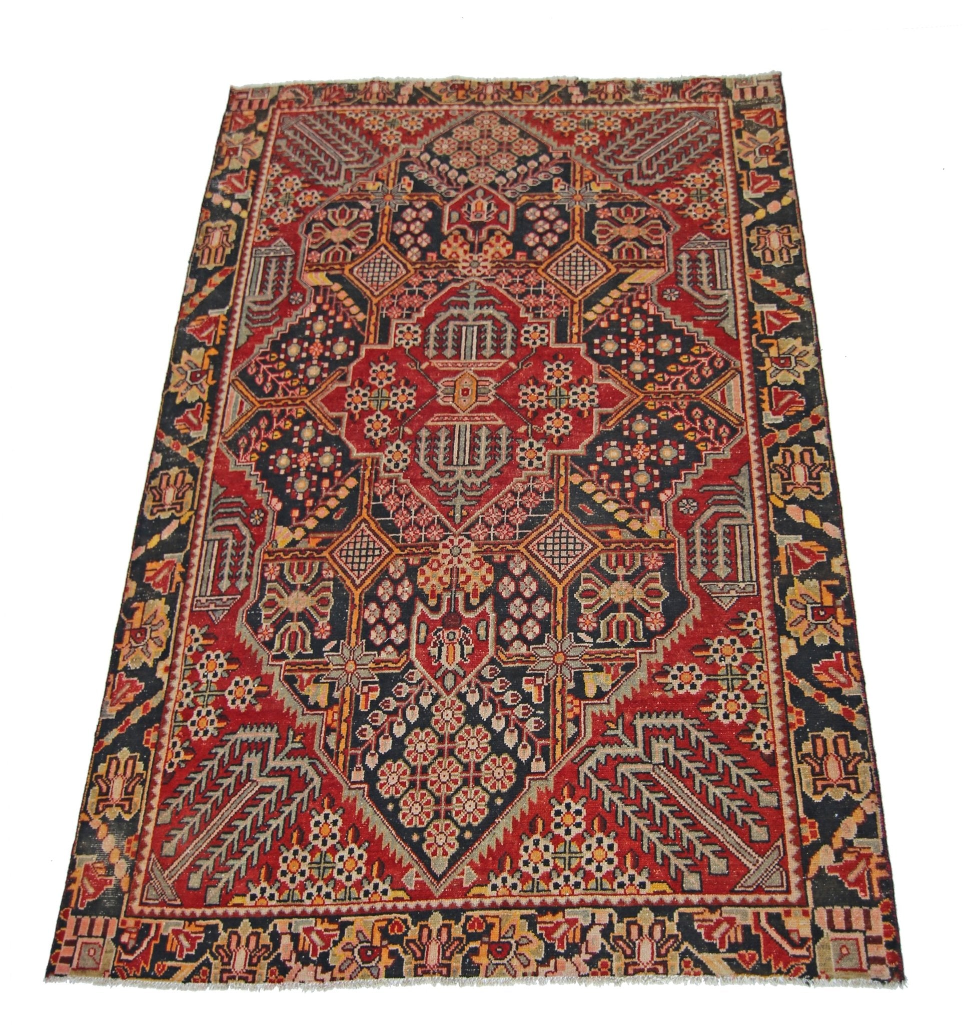 A vintage Persian Tabriz rug featuring a geometric floral pattern in red, black, and cream tones.