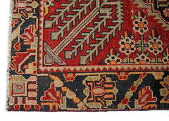 A vintage Persian Tabriz rug featuring a geometric floral pattern in red, black, and beige.