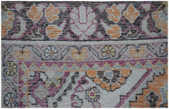 A close-up of a vintage Persian Tabriz rug featuring intricate floral patterns in orange and pink.