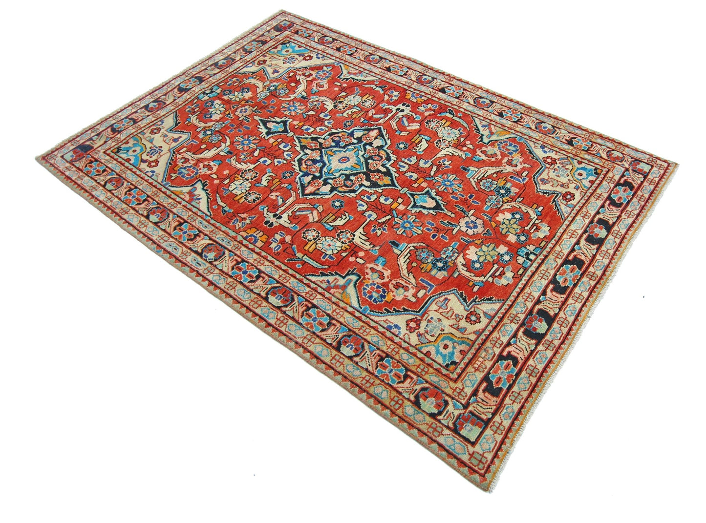 A vintage Persian Tabriz rug featuring a central floral medallion on a red field with intricate borders.