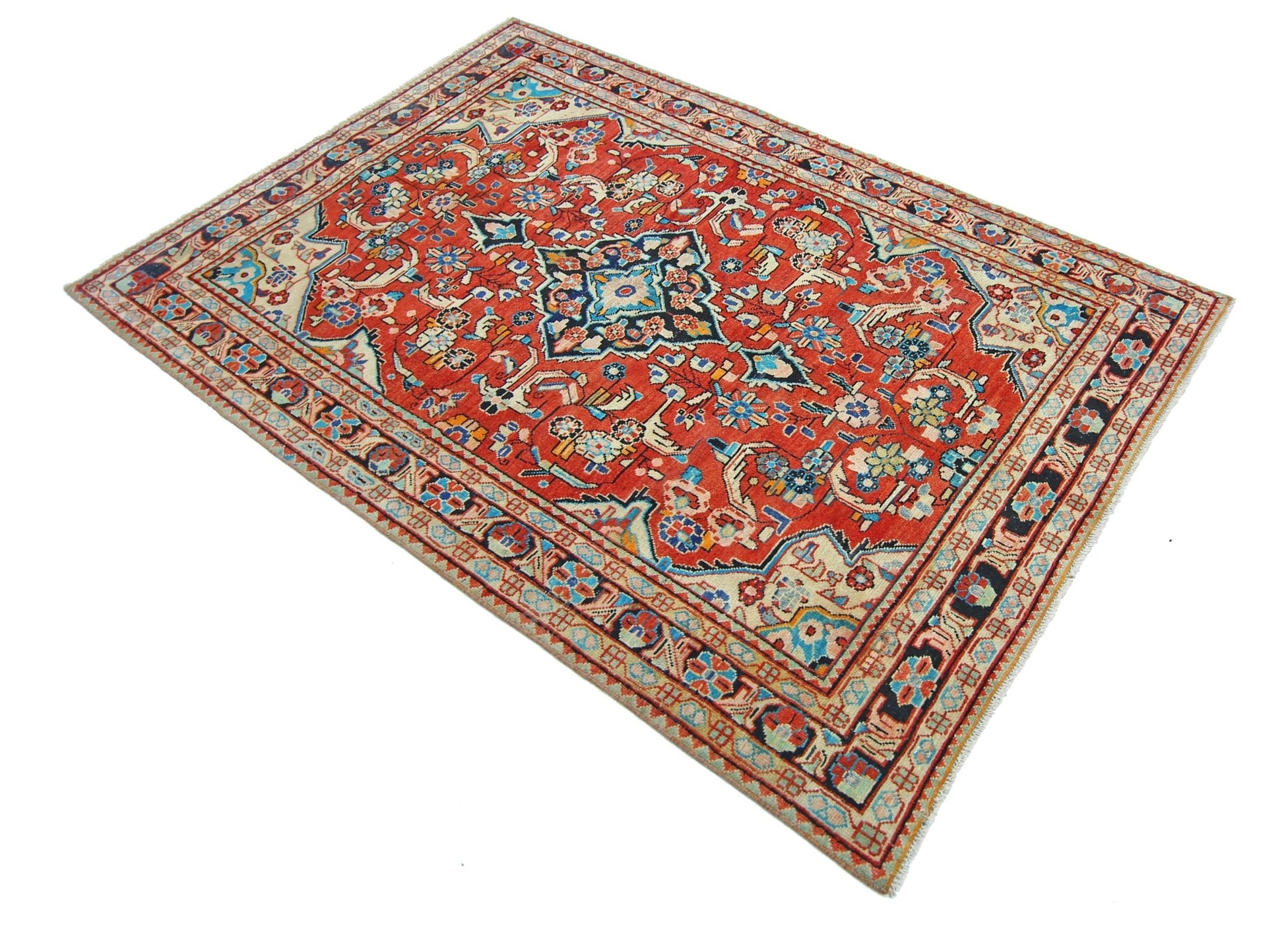 A vintage Persian Tabriz rug featuring a central floral medallion on a red field with intricate borders.