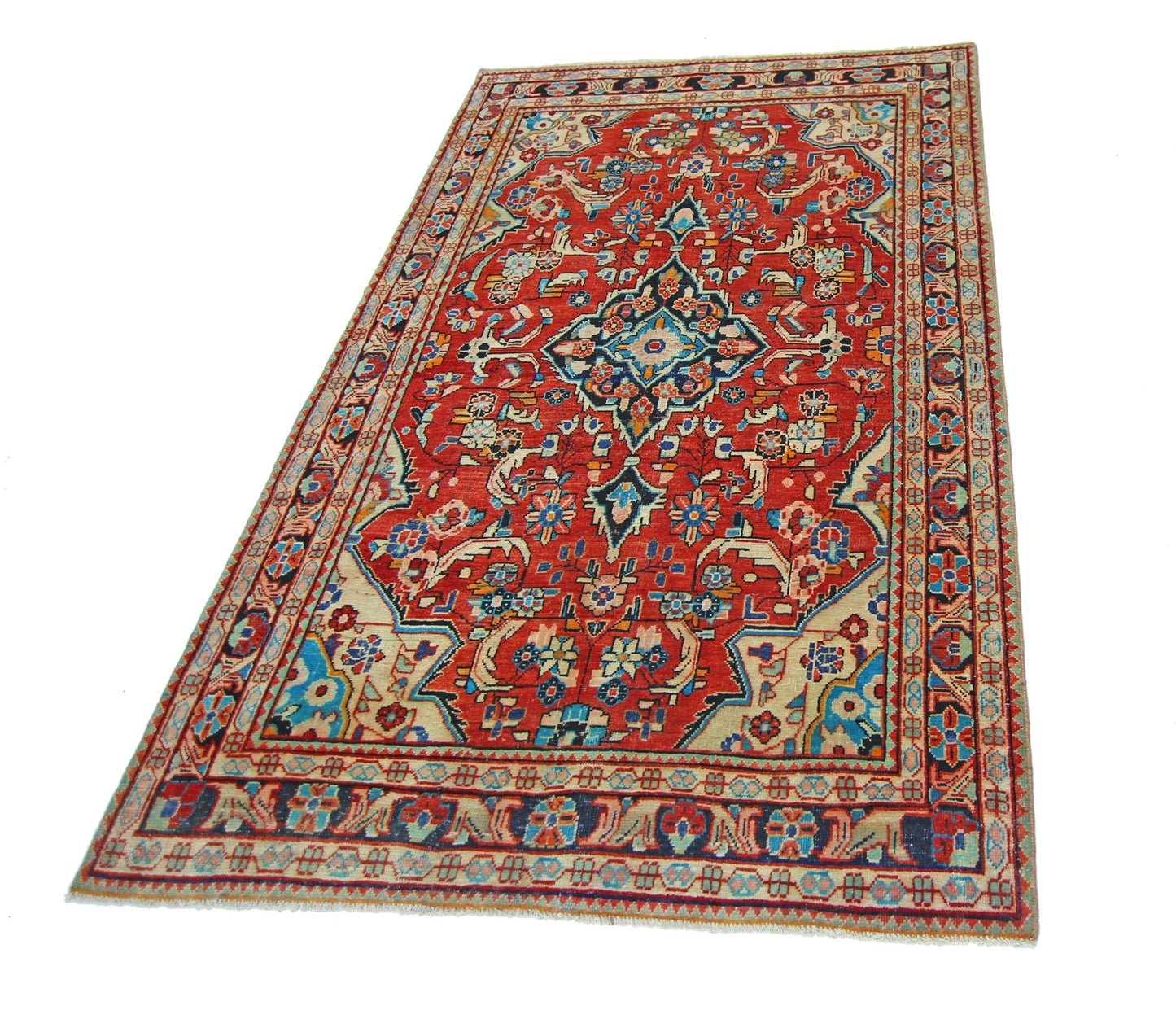 A vintage Persian Tabriz rug featuring a central floral medallion on a red field with ornate borders.