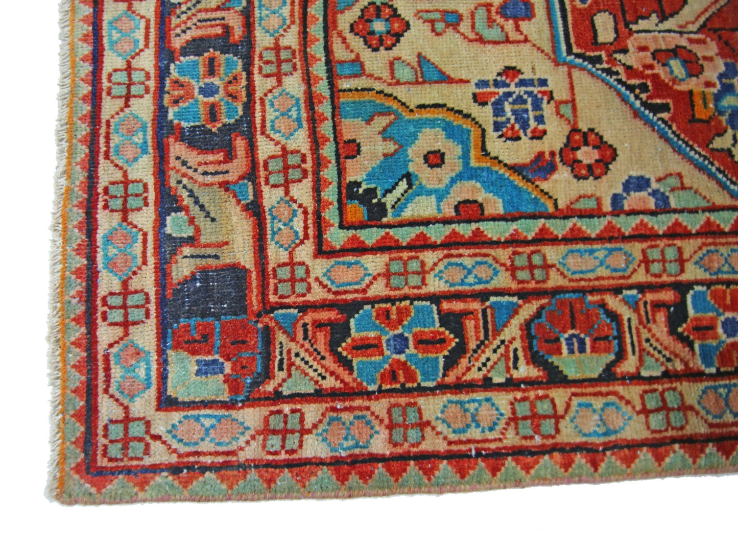 A corner view of a vintage Persian Tabriz rug featuring intricate floral patterns in vibrant colors.