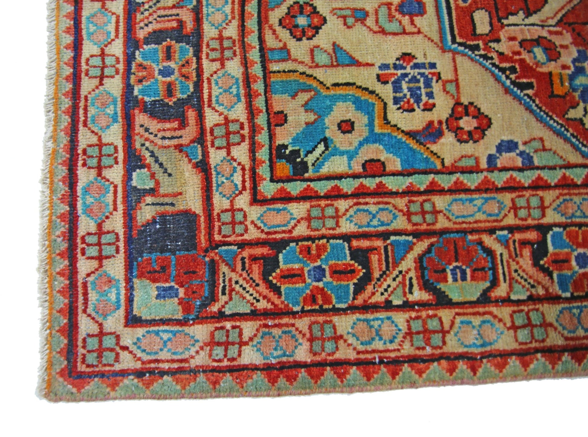 A corner view of a vintage Persian Tabriz rug featuring intricate floral patterns in vibrant colors.