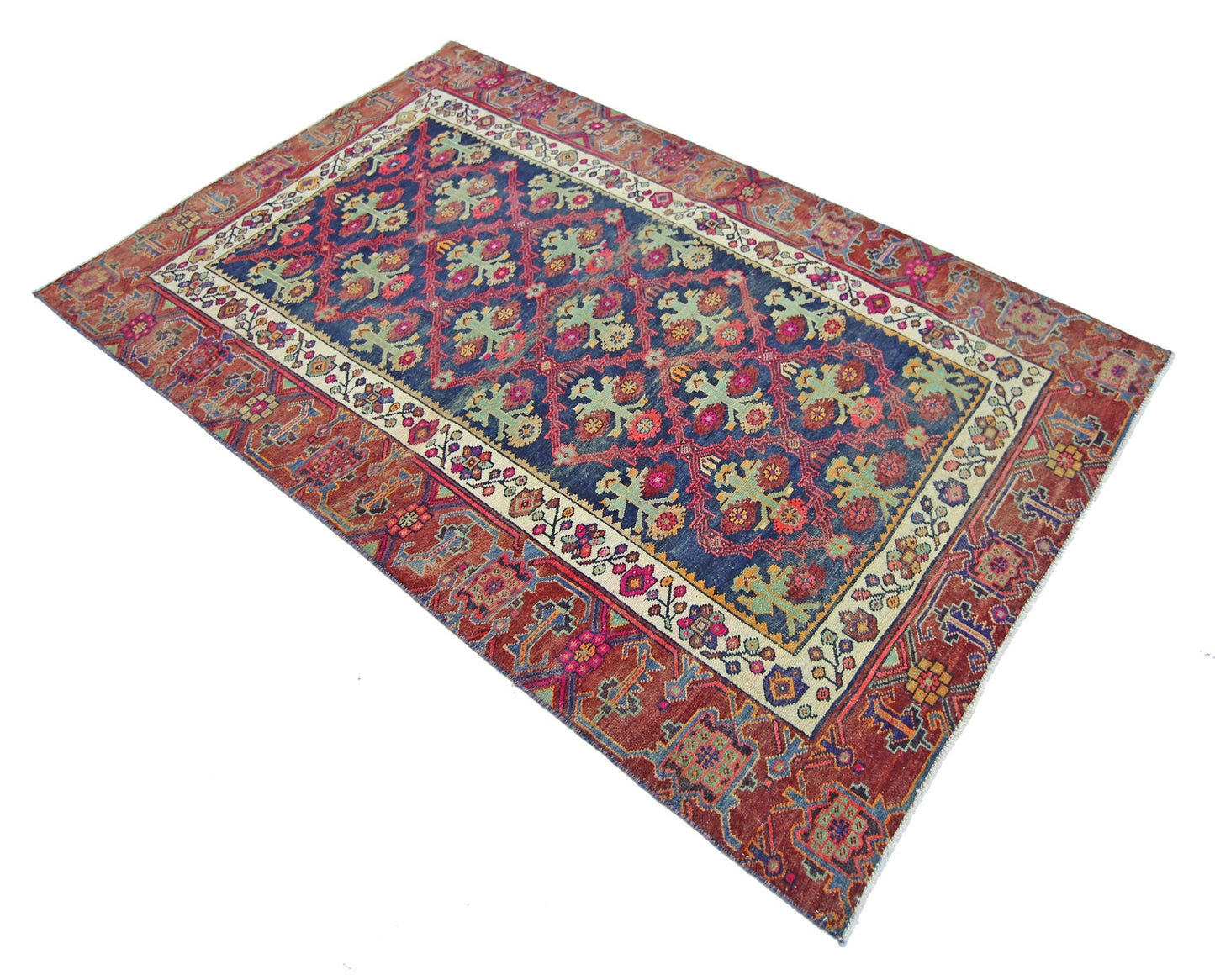 A vintage Persian Tabriz rug featuring a blue field with floral motifs and a red border.