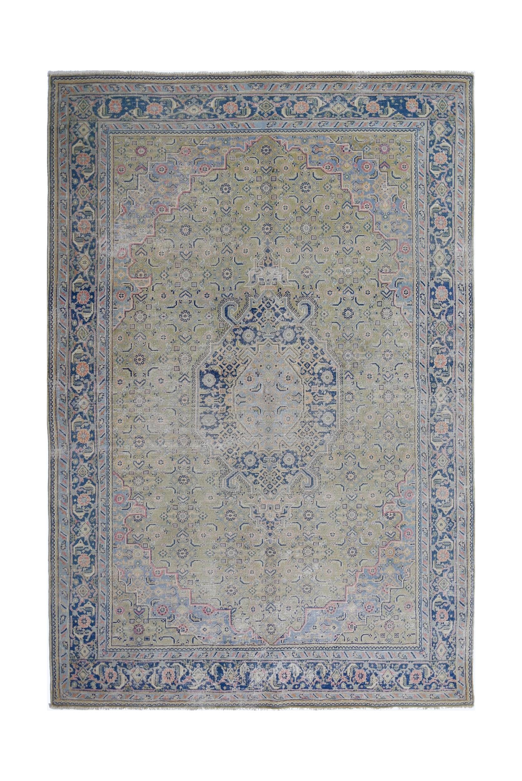 A vintage Persian Tabriz rug featuring a central blue medallion on a muted green field.