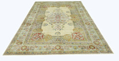 A vintage Persian Tabriz rug featuring a central floral medallion on a cream field.