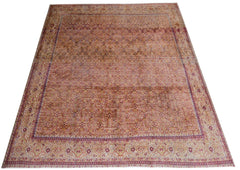 A vintage Persian Tabriz rug featuring an intricate floral pattern in soft, warm tones.