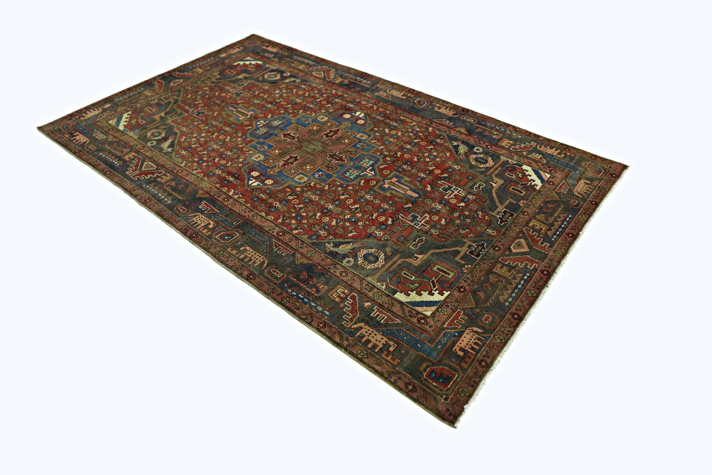 A vintage Persian Tabriz rug featuring a detailed geometric pattern in red, blue, and brown tones.