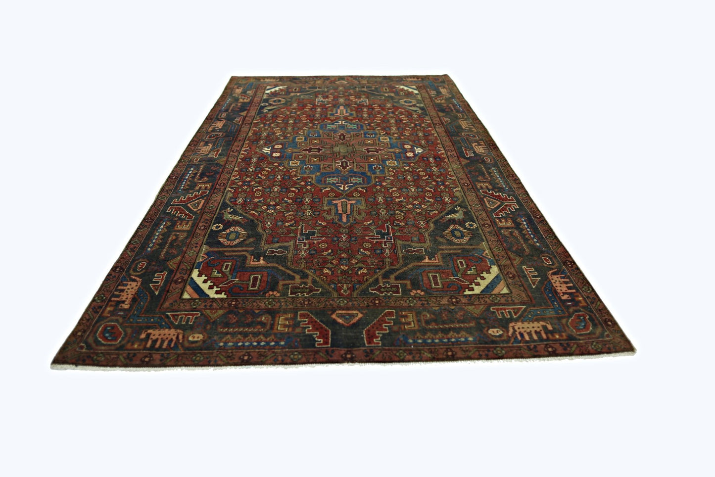 A vintage Persian Tabriz rug featuring intricate geometric patterns in red, blue, and brown tones.