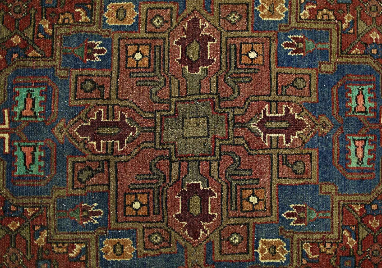 A vintage Persian Tabriz rug featuring a geometric medallion pattern in red, blue, and tan tones.
