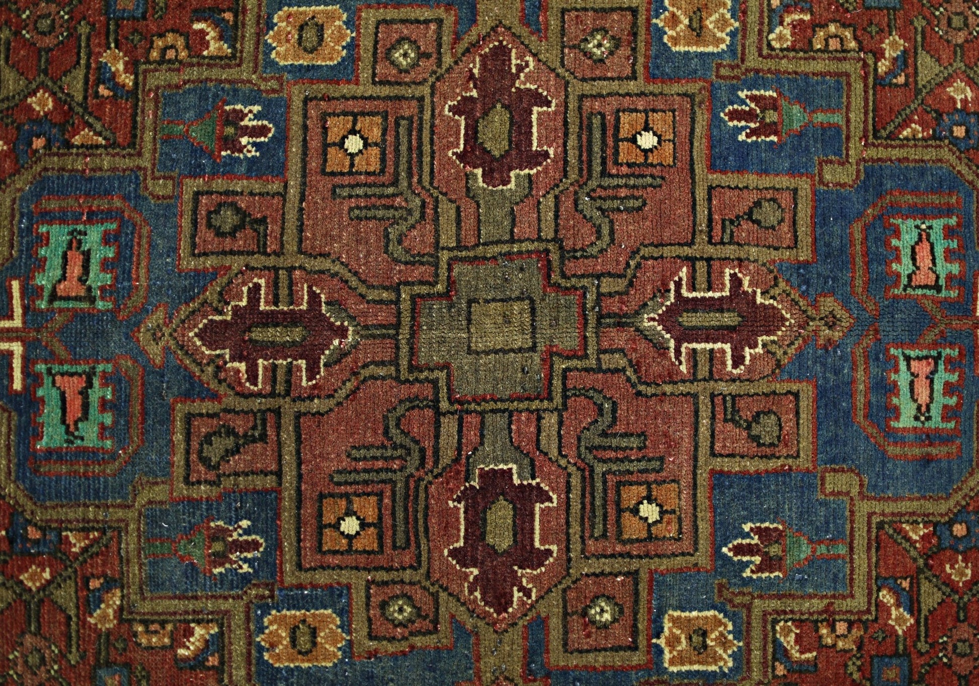 A vintage Persian Tabriz rug featuring a geometric medallion pattern in red, blue, and tan tones.
