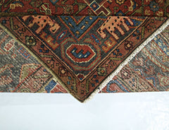 A folded vintage Persian Tabriz rug featuring intricate geometric patterns in red, blue, and brown.