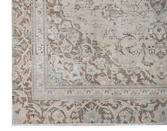 A vintage Persian Kerman rug featuring an intricate floral medallion design in beige and blue tones.
