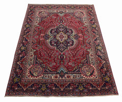 A vintage Persian Tabriz rug featuring a central medallion and intricate floral patterns in red.