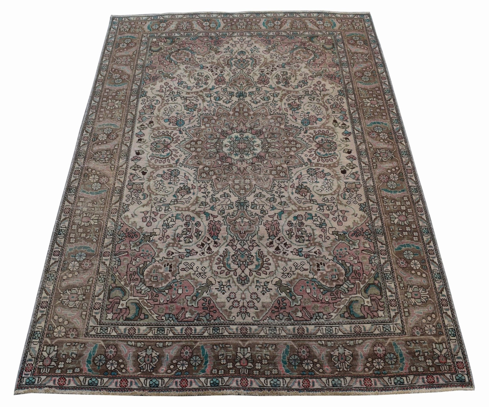 A vintage handwoven Persian Tabriz rug featuring intricate floral patterns in muted earth tones.
