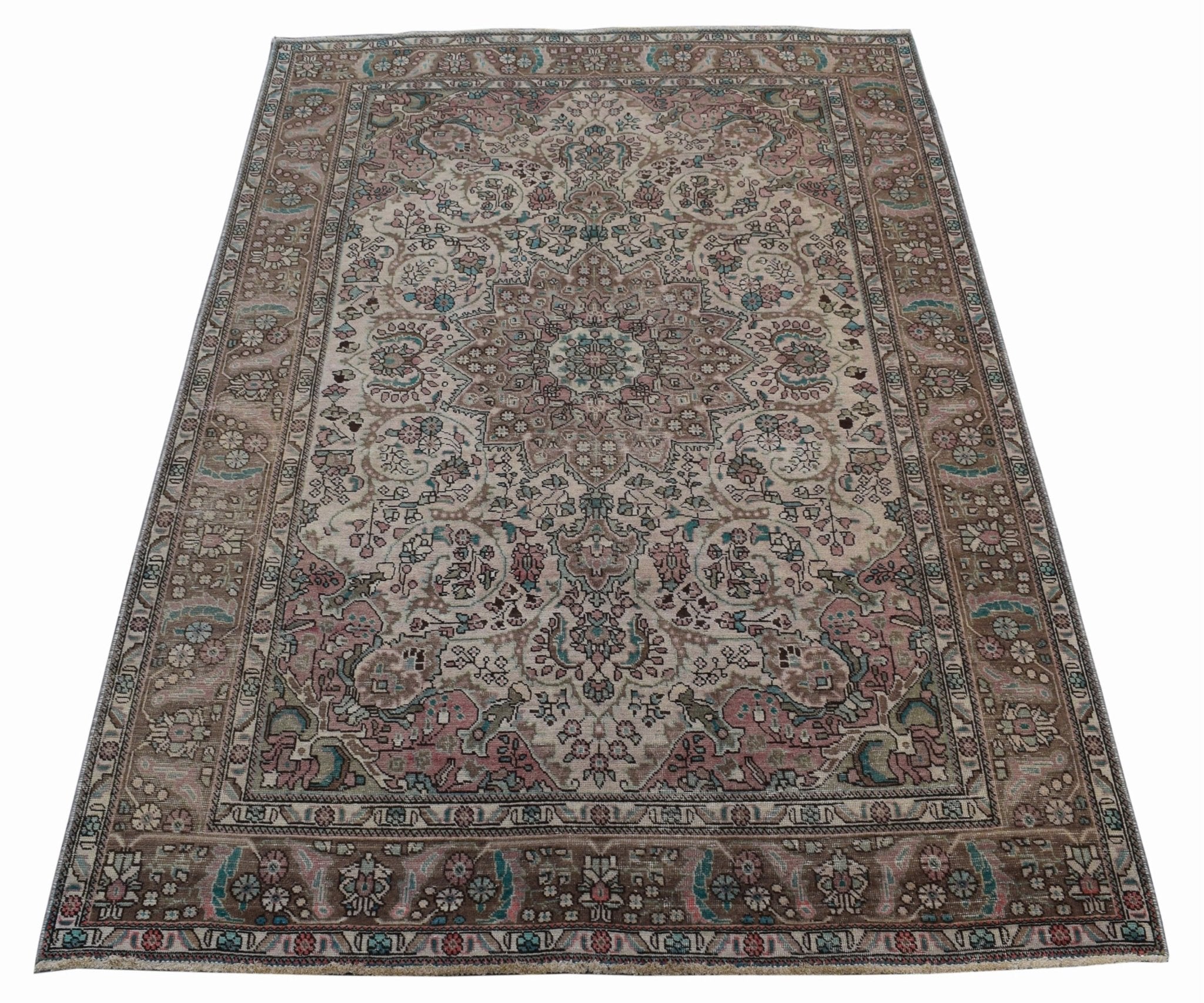 A vintage handwoven Persian Tabriz rug featuring intricate floral patterns in muted earth tones.