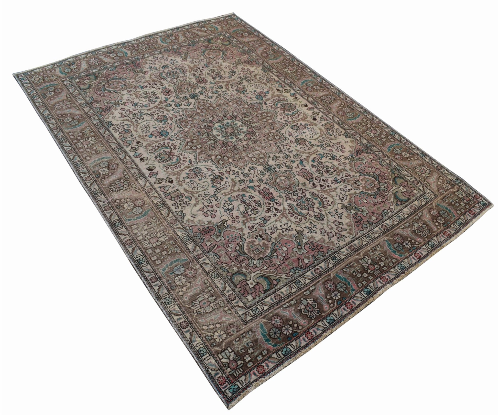 A vintage handwoven Persian Tabriz rug featuring intricate floral patterns in muted earth tones.