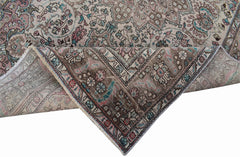 A vintage Persian Tabriz rug featuring intricate floral patterns in muted tones of pink and blue.