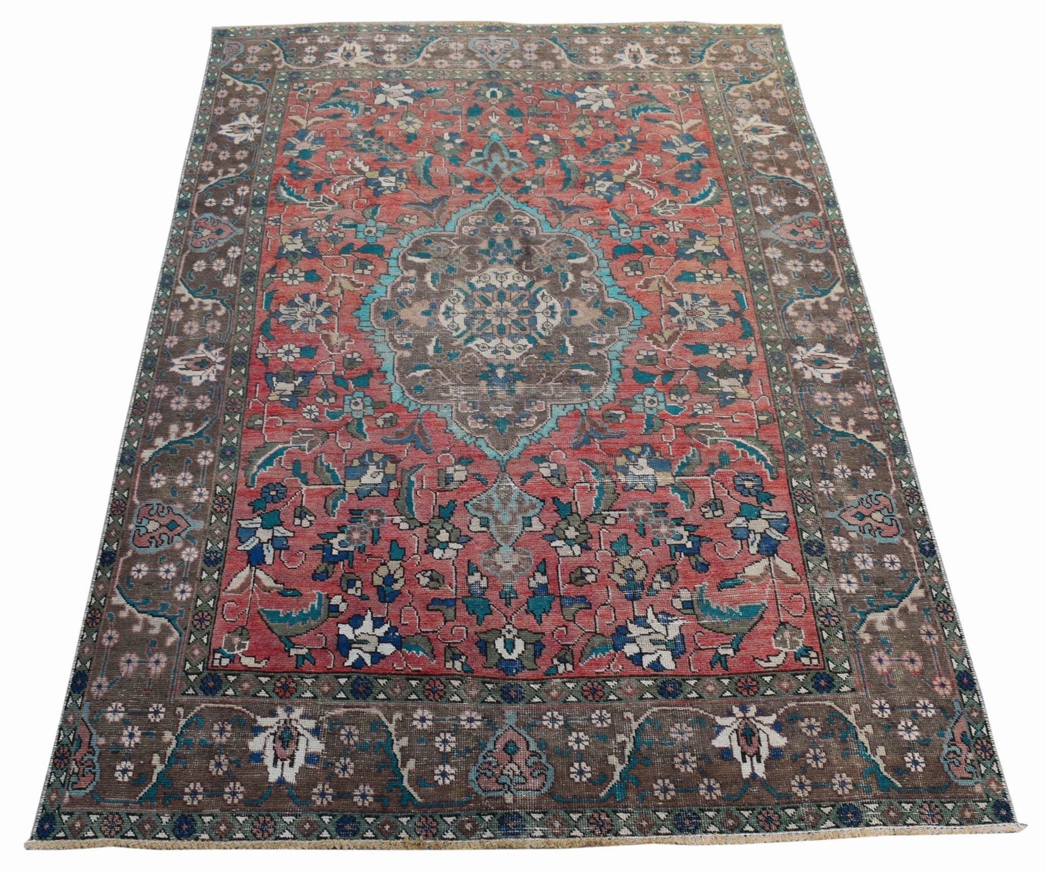 A vintage Persian Tabriz rug featuring a central medallion and intricate floral patterns in red.