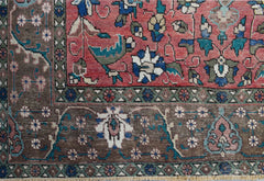 A vintage Persian Tabriz rug featuring intricate floral patterns in red, brown, and blue tones.