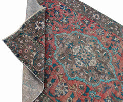 A vintage Persian Tabriz rug featuring a central medallion and intricate floral patterns in red.