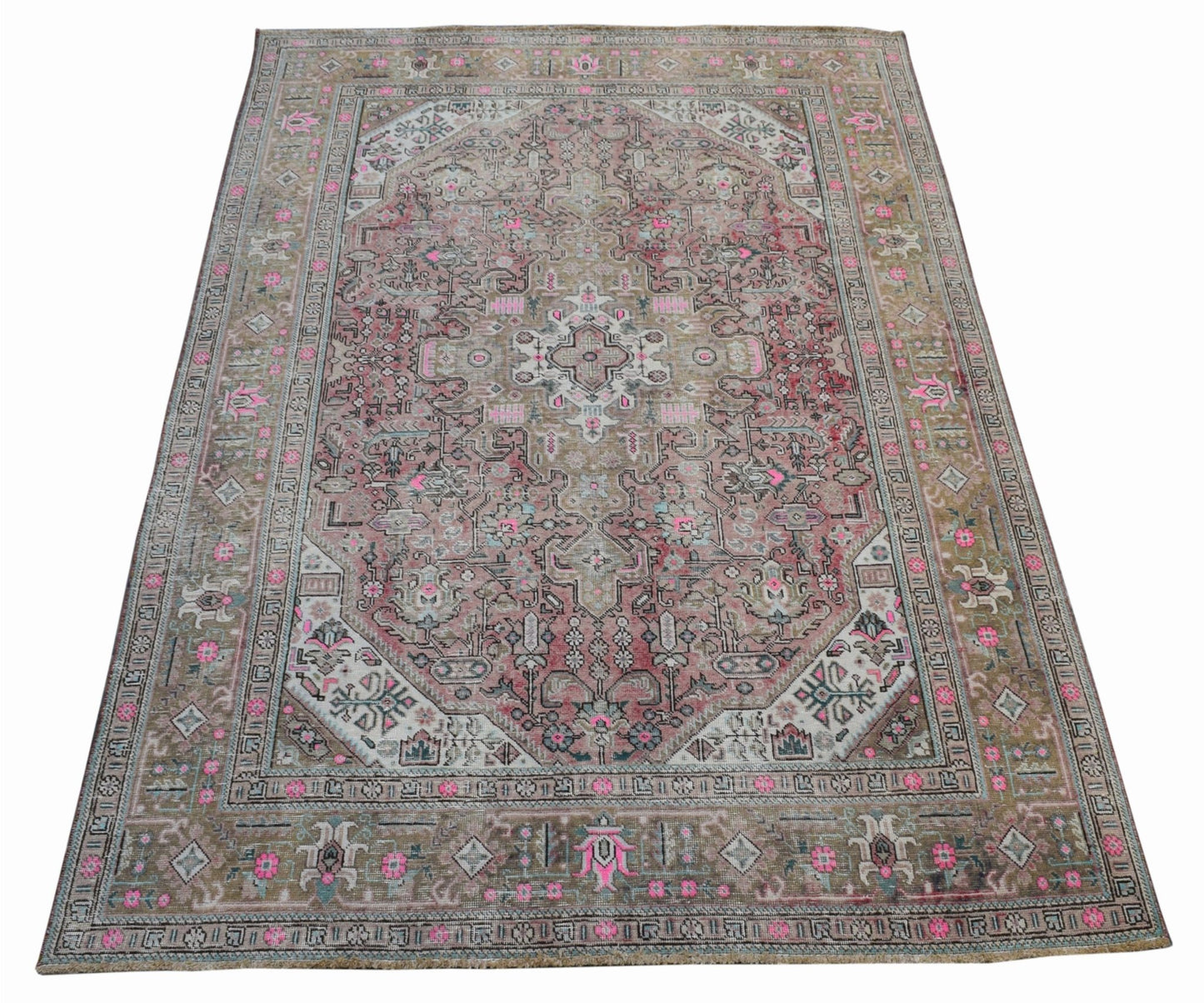 A vintage handwoven Persian Tabriz rug featuring intricate floral patterns in pink and beige tones.