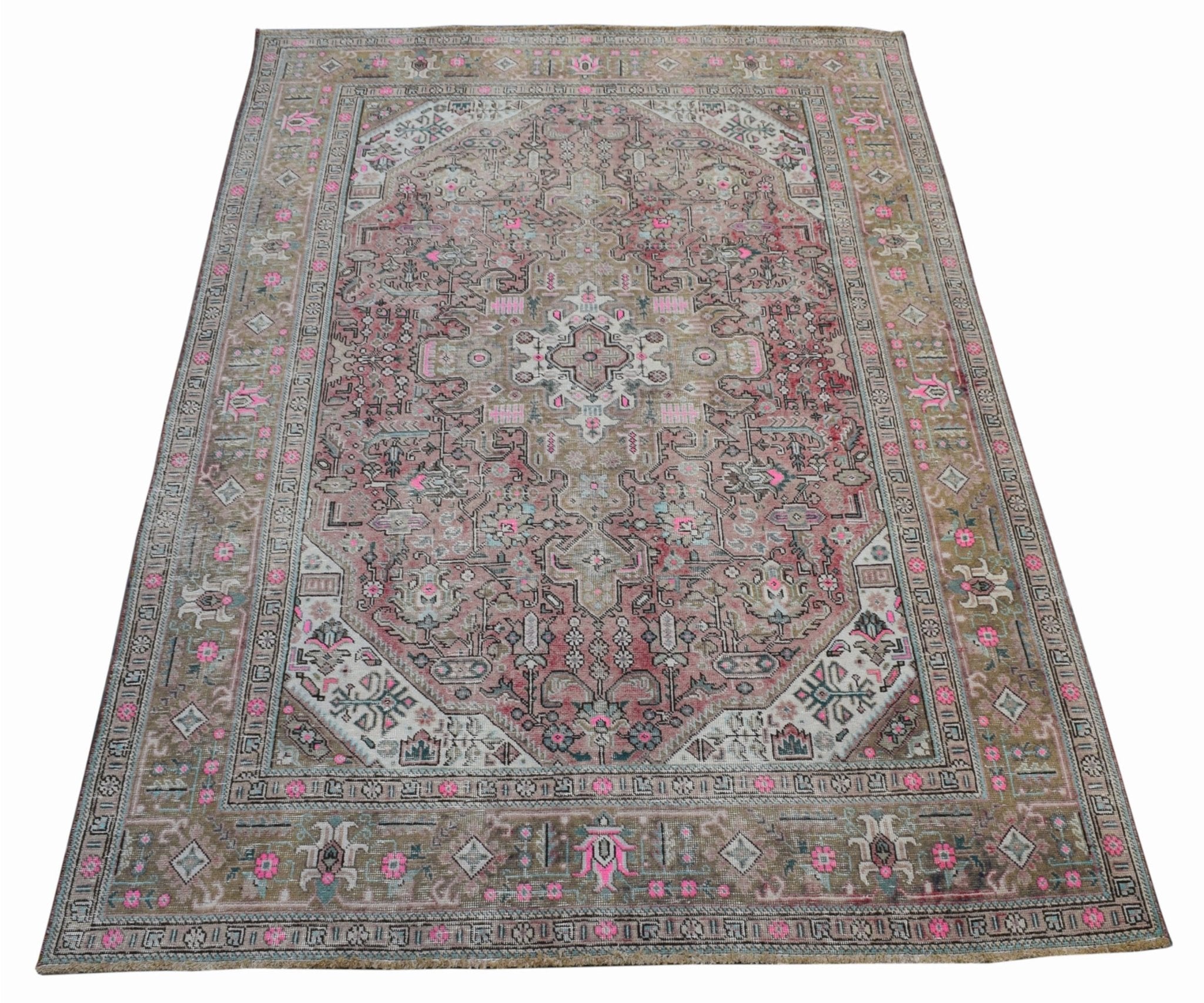 A vintage handwoven Persian Tabriz rug featuring intricate floral patterns in pink and beige tones.