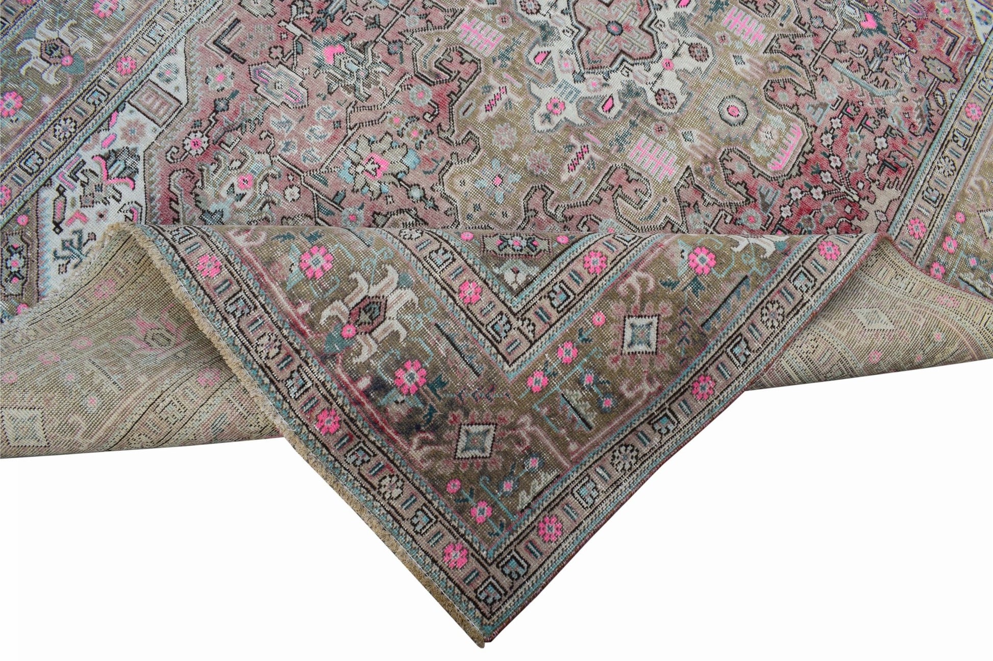 A vintage Persian Tabriz rug featuring intricate floral patterns in muted tones with pink accents.