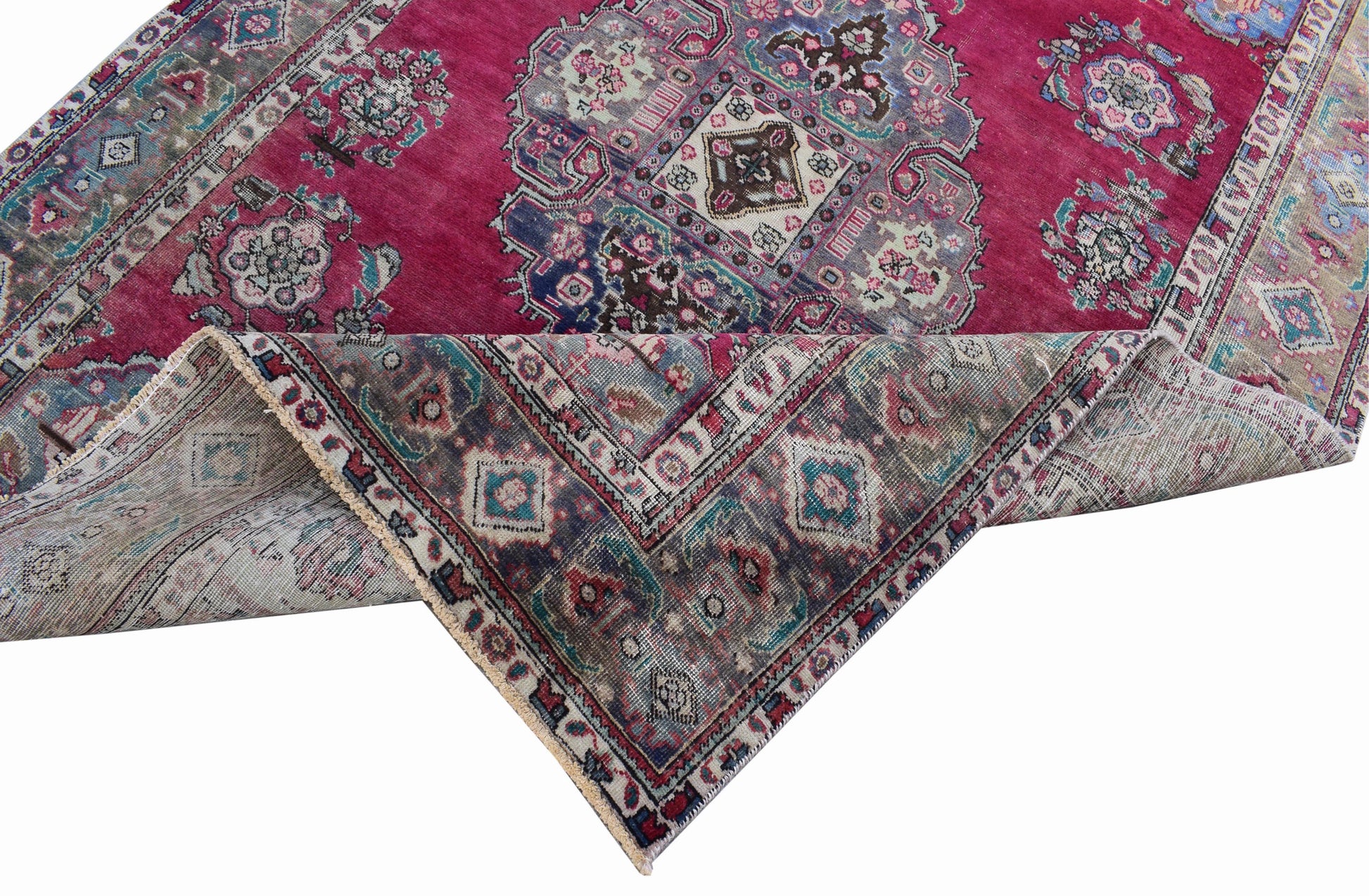 A vintage Persian Tabriz rug with a magenta field, central medallion, and intricate floral motifs.