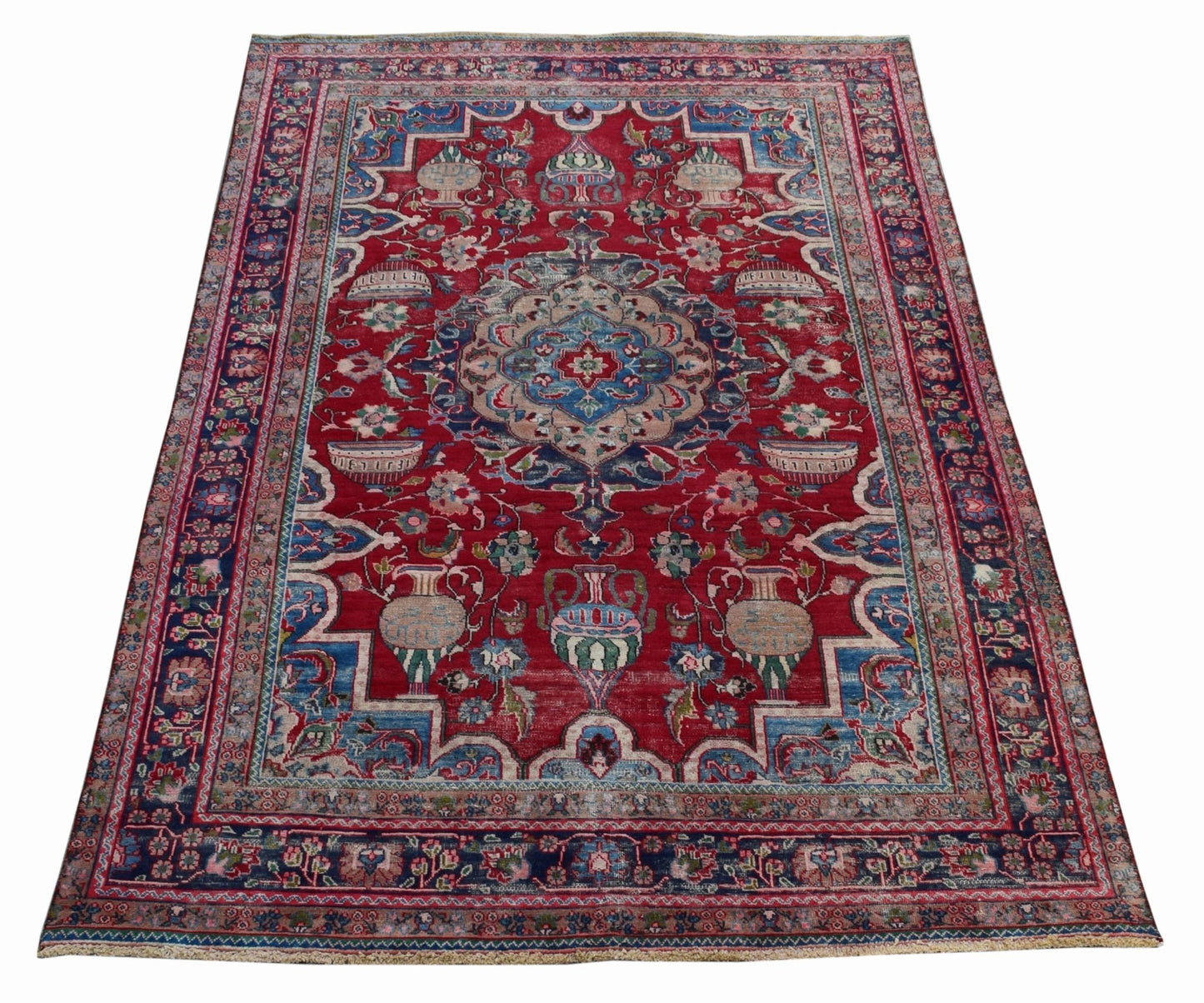 A vintage Persian Tabriz rug featuring a central medallion and intricate floral vase motifs.