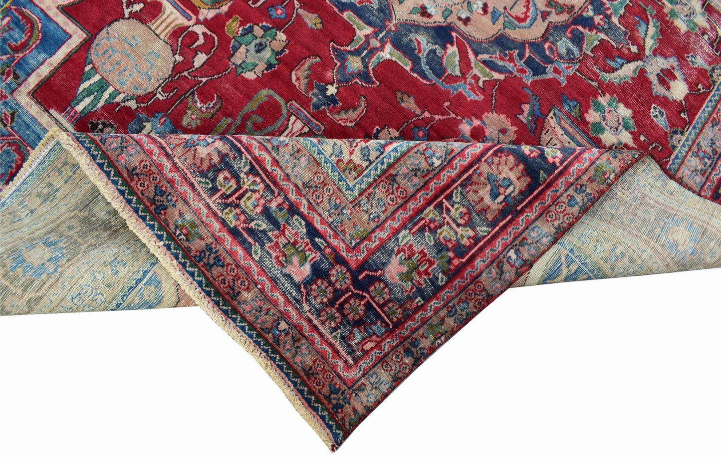 A vintage Persian Tabriz rug featuring a red field with intricate floral patterns and a medallion.
