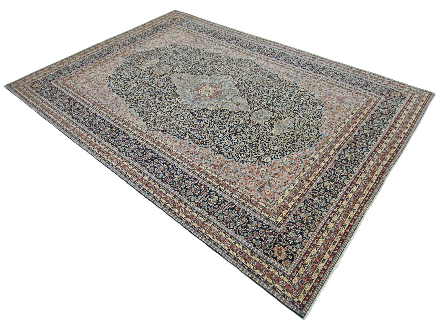 A vintage Persian Tabriz rug featuring an intricate floral medallion pattern in navy and cream.
