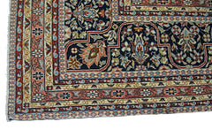 A vintage Persian Tabriz rug featuring intricate floral patterns in navy, pink, and cream.