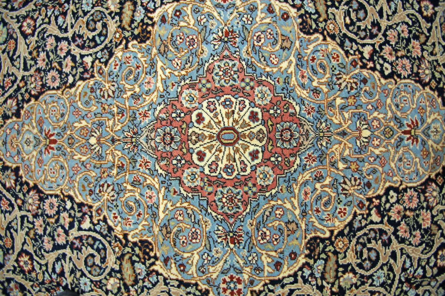 A vintage Persian Tabriz rug featuring an intricate floral medallion pattern in blue and red.