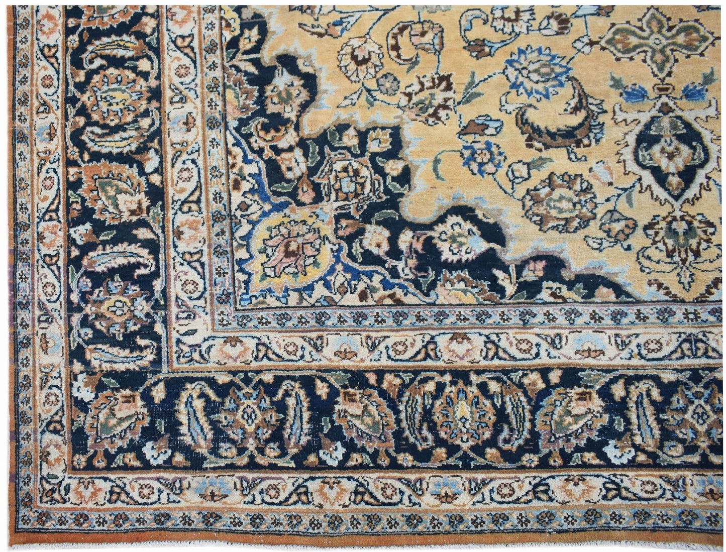 A vintage Persian Kerman rug featuring an intricate floral medallion design in blue and gold tones.