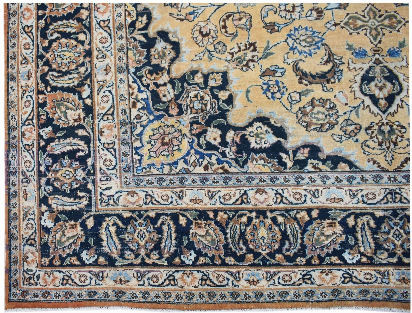 A vintage Persian Kerman rug featuring an intricate floral medallion design in blue and gold tones.