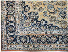 A vintage Persian Kerman rug featuring an intricate floral medallion design in blue and gold tones.