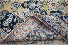 A vintage Persian Kerman rug featuring an intricate floral medallion design in blue and gold tones.