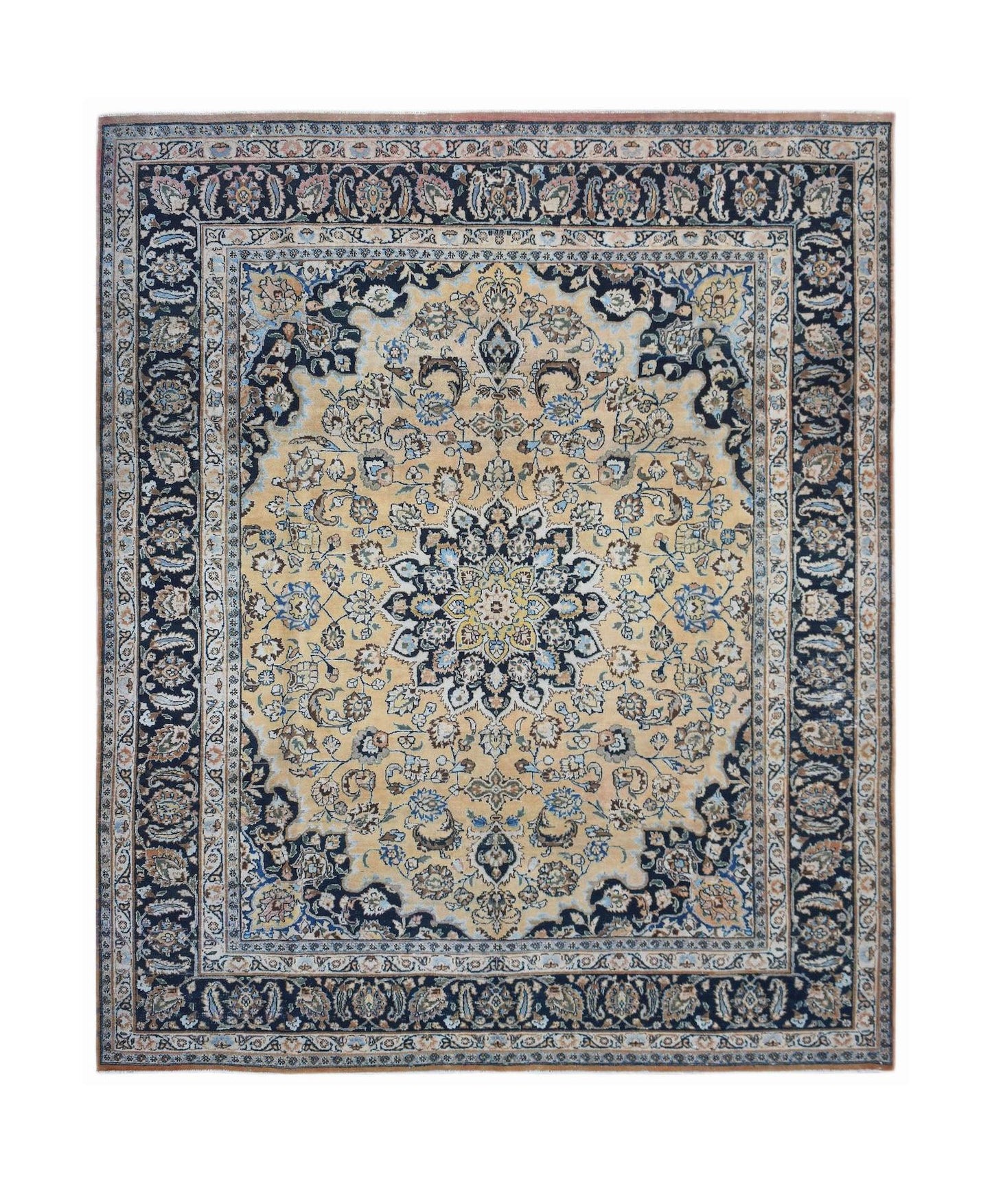 A vintage Persian Kerman rug featuring a central floral medallion on a beige field with dark borders.