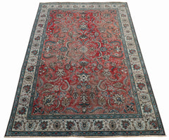 A vintage Persian Tabriz rug featuring an intricate floral medallion design in red and blue tones.