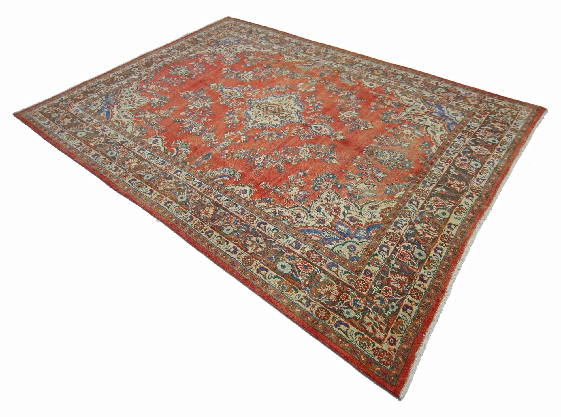 A vintage Persian Tabriz rug featuring an intricate floral pattern in red, blue, and cream tones.