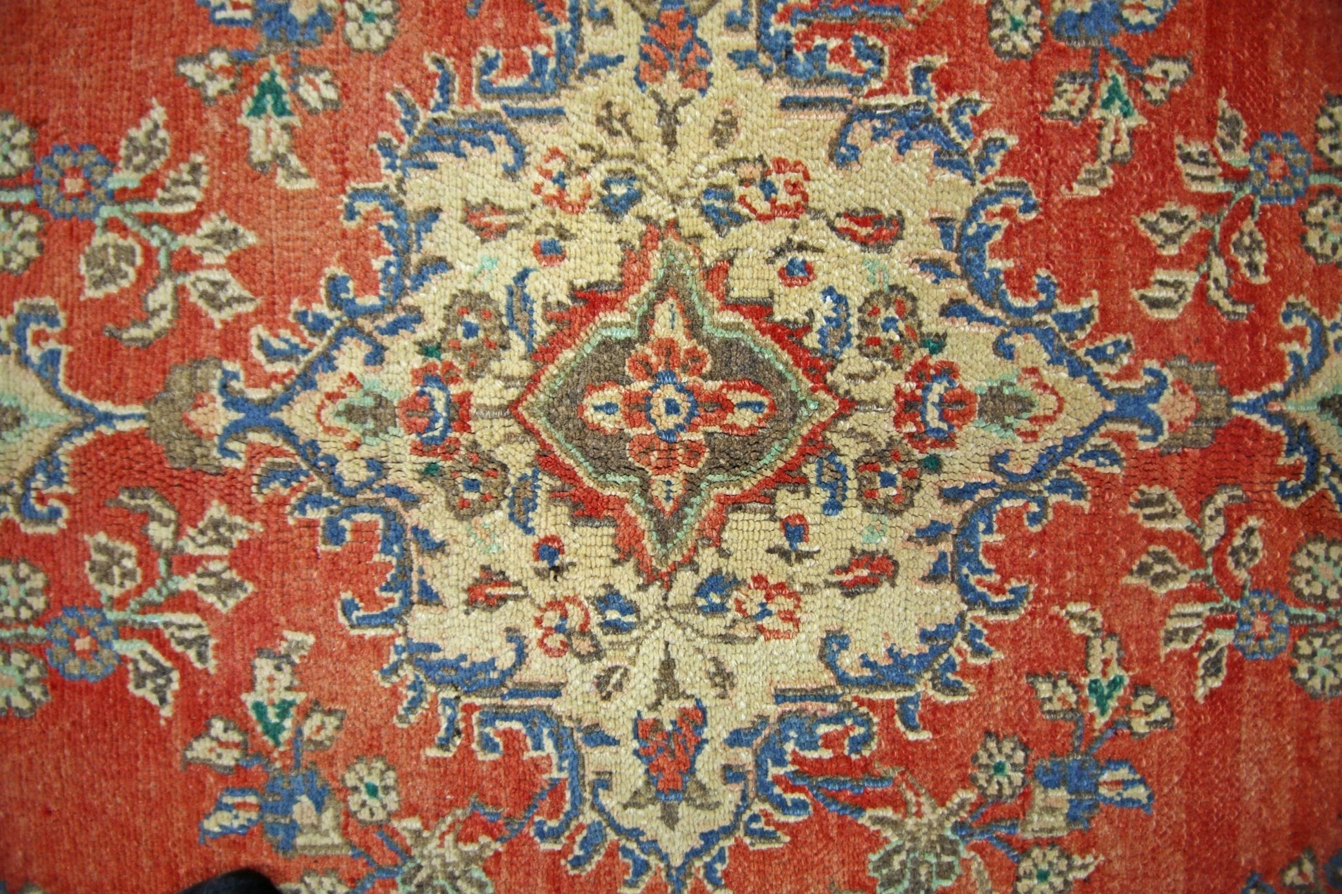 A vintage Persian Tabriz rug featuring a central floral medallion on a red field.