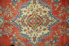 A vintage Persian Tabriz rug featuring a central floral medallion on a red field.