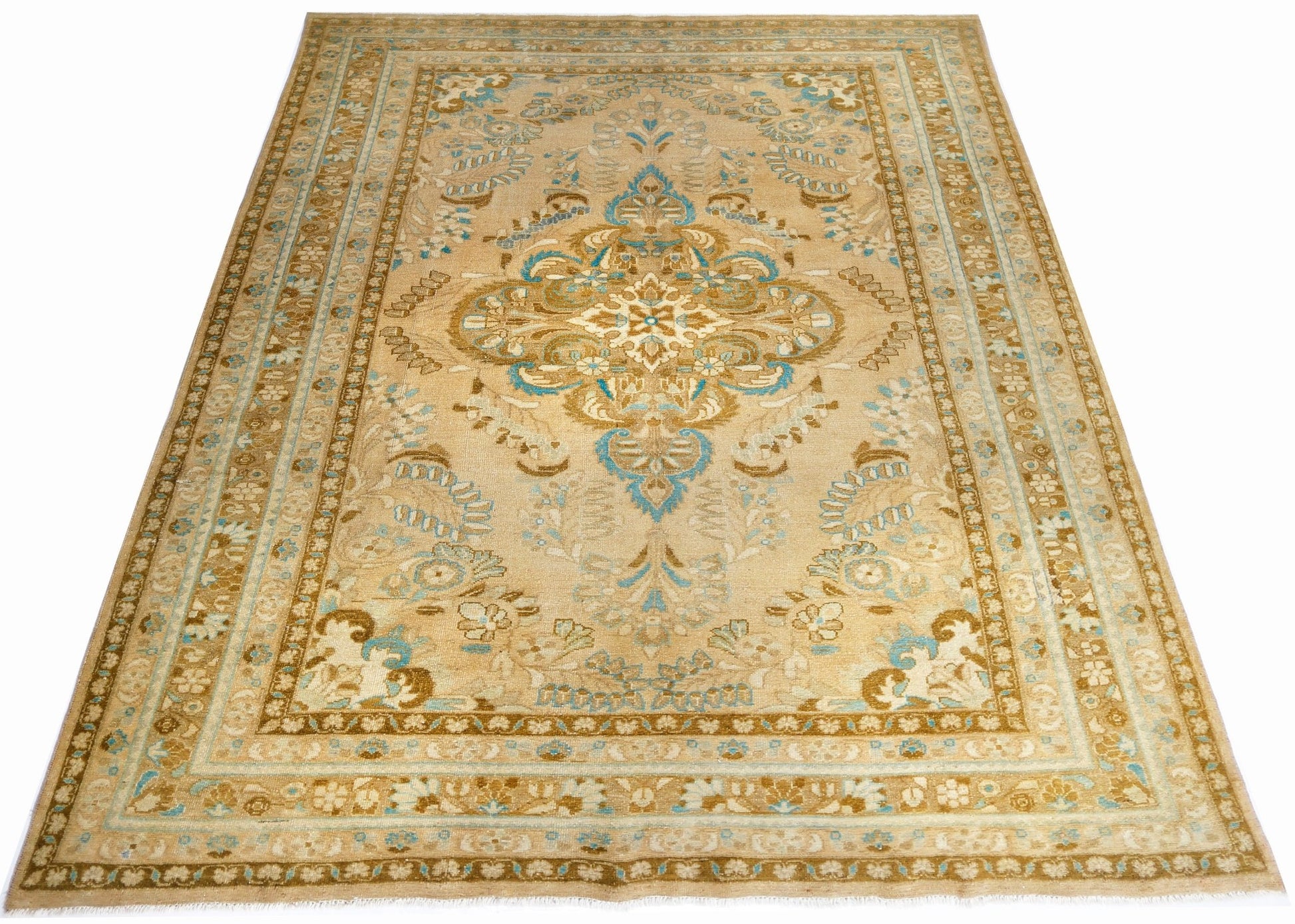 A vintage Persian Tabriz rug featuring a central floral medallion in blue and beige tones.