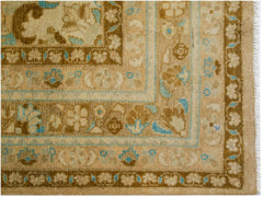 A vintage Persian Tabriz rug featuring intricate floral patterns in shades of brown and blue.