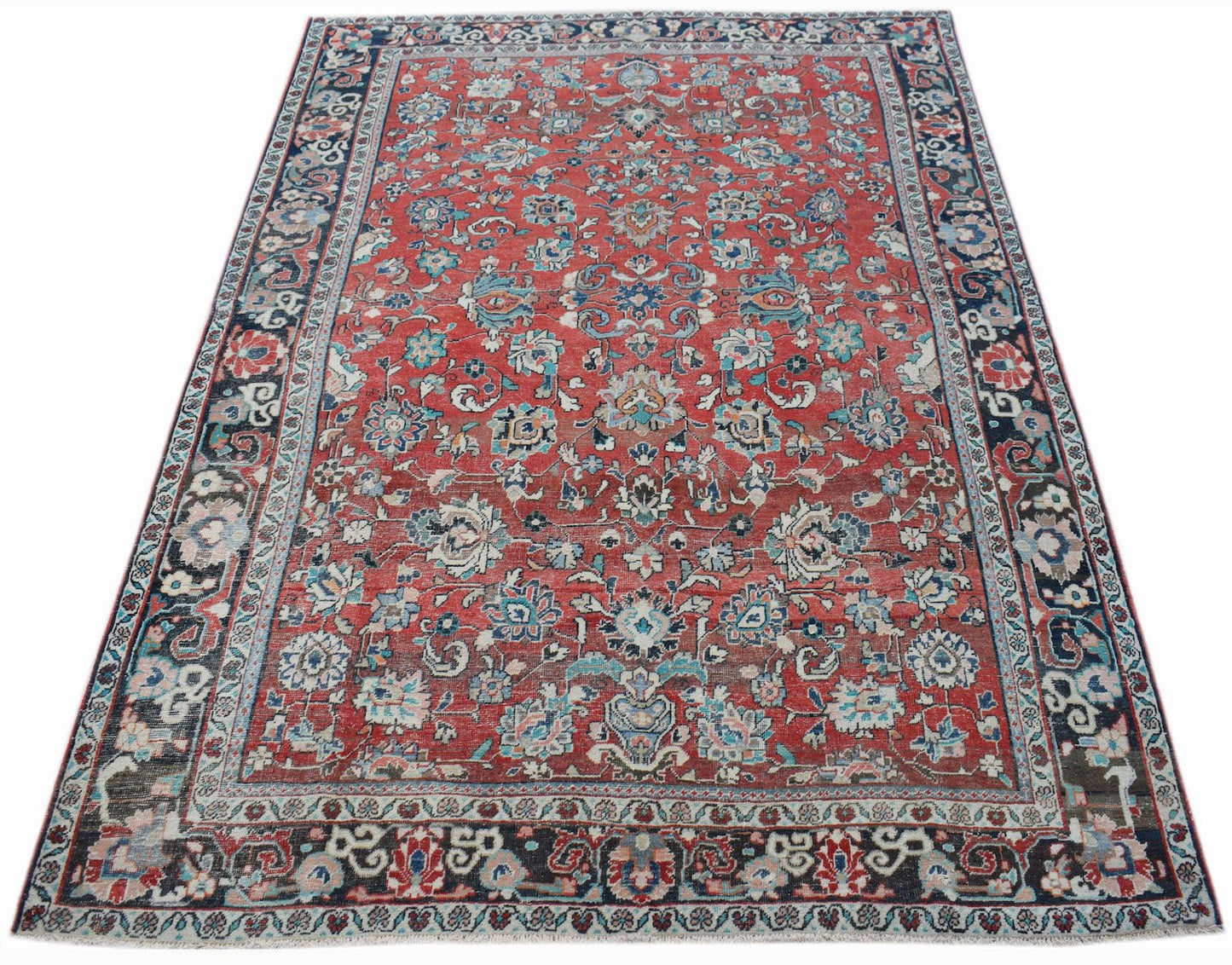 A vintage handwoven Persian Tabriz rug featuring intricate floral patterns in red and blue tones.