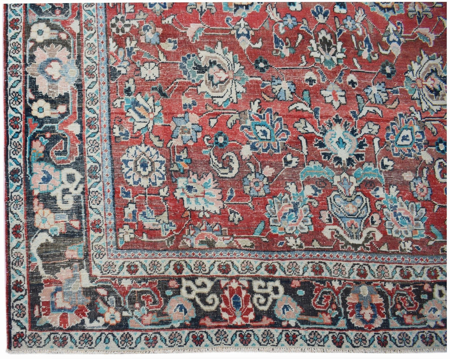 A vintage handwoven Persian Tabriz rug featuring intricate floral patterns in red and blue tones.